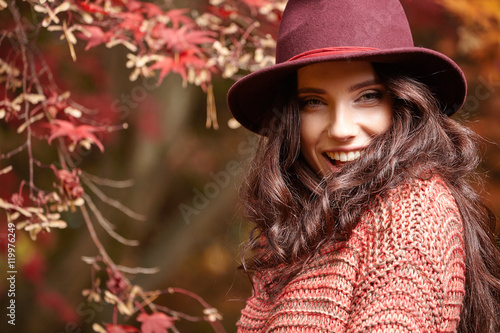Fashionable woman and fall yellow, red  maple park  background. © ZoomTeam