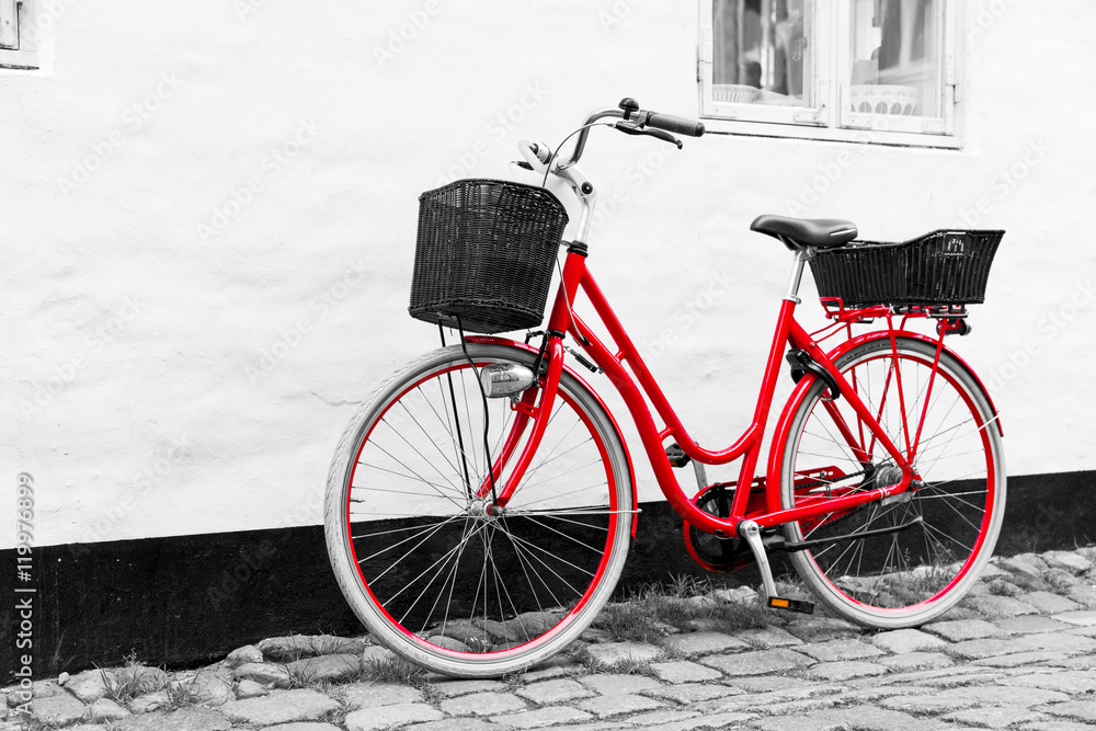 Retro vintage red bicycle on cobblestone street in the old town.