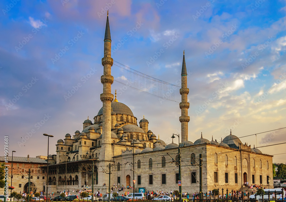 New mosque - Yeni Cami against the cloudy sky at sunset in Eminonu district of Istanbul, Turkey