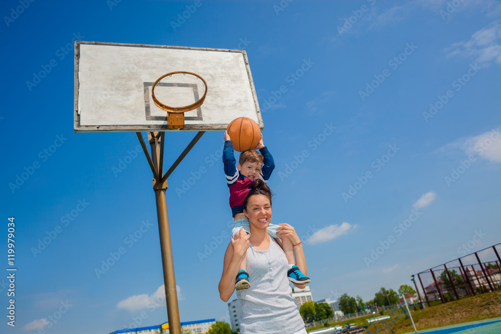 Fototapeta premium Mom and little boy son playing basketball