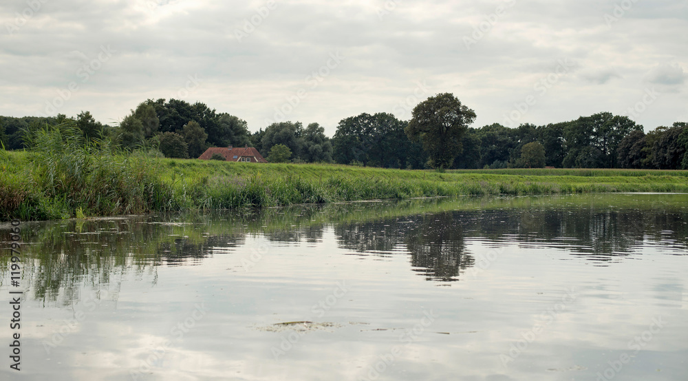 Dutch river de Berkel with dyke and farm. Achterhoek. Gelderland