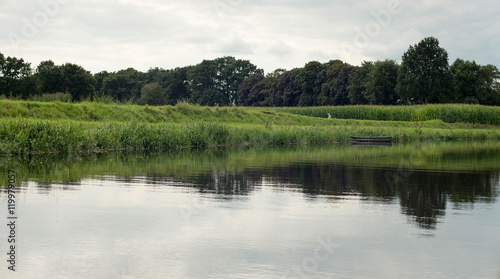 Dutch river de Berkel with small boat corn field. Achterhoek. Ge