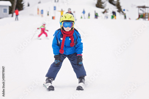 Young child, skiing on snow slope in ski resort in Austria