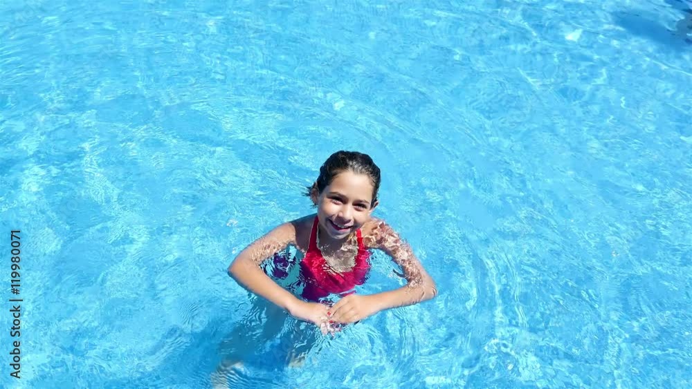 Cute little girl dancing in the water of a pool Cute little girl dancing in the water of a pool