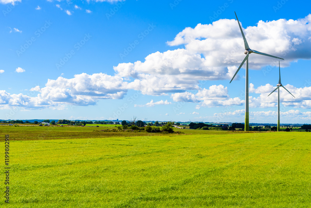 Sustainable energy from wind turbines in flat farmland with fine clouds overhead. Skane in southern Sweden. Sustainable energy from wind turbines in flat farmland with fine clouds overhead. Skane in southern Sweden.