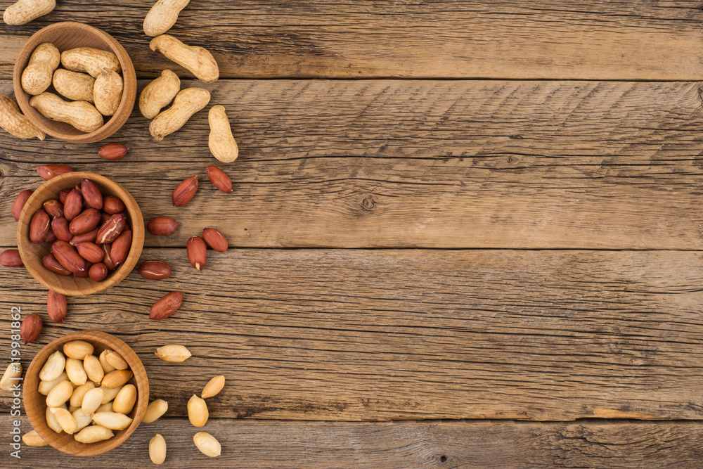 Peanuts in wooden masks on the old wooden table. Peanuts in wooden masks on the old wooden table.