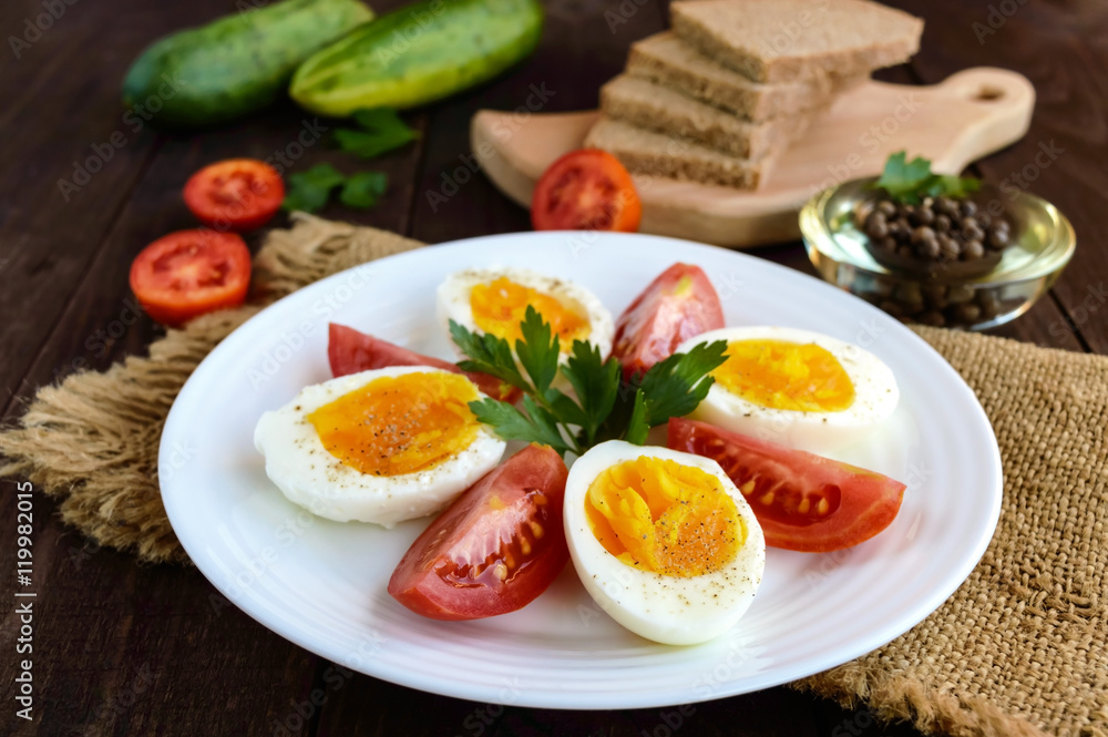 Boiled egg and fresh tomato, black bread - light diet breakfast.