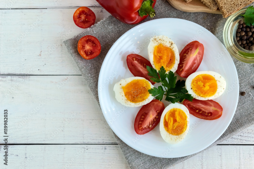 Boiled egg and fresh tomato, black bread - light diet breakfast. The top view Boiled egg and fresh tomato, black bread - light diet breakfast. The top view