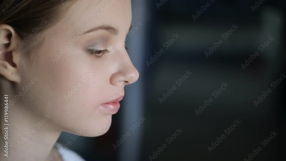 Close up view of young and beautiful woman is sitting in room. Close up view of young and beautiful woman is sitting in room.