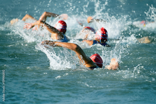 Group people in wetsuit swimming at triathlon