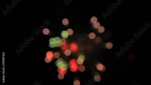 White, blueviolet, red and green flower of fireworks opening. Bokeh.