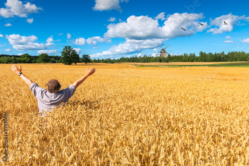 Happy man among the field of ripening wheat