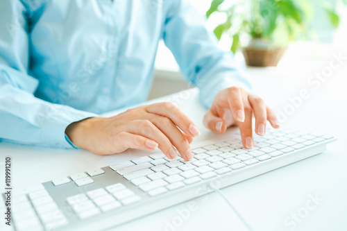 Woman office worker typing on the keyboard © vladstar