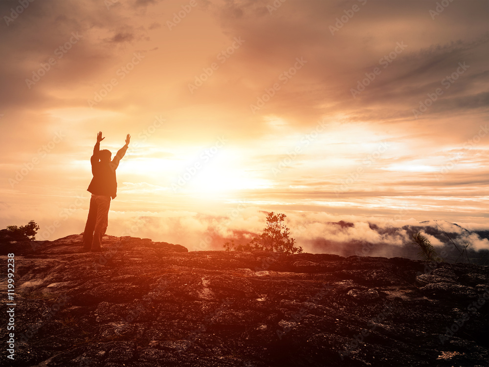 Fototapeta premium silhouette of a man standing to watch colorful sunset
