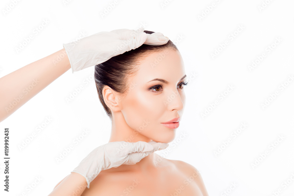 Doctor in medical gloves examining woman's face after surgery Doctor in medical gloves examining woman's face after surgery
