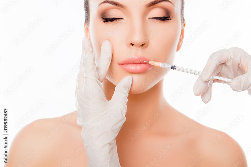 Plastic surgery. Young woman geting cosmetic injection in lips