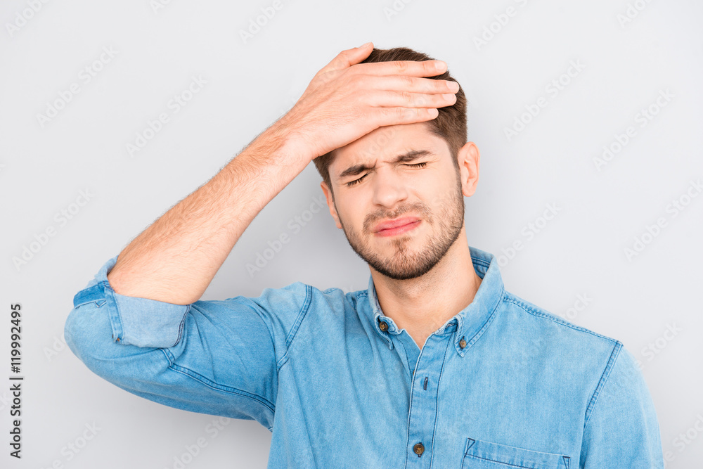 Portrait of overworked sad man with headache on gray background Portrait of overworked sad man with headache on gray background