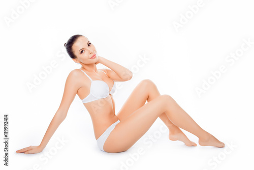 Attractive sensitive slim woman sitting in white underwear