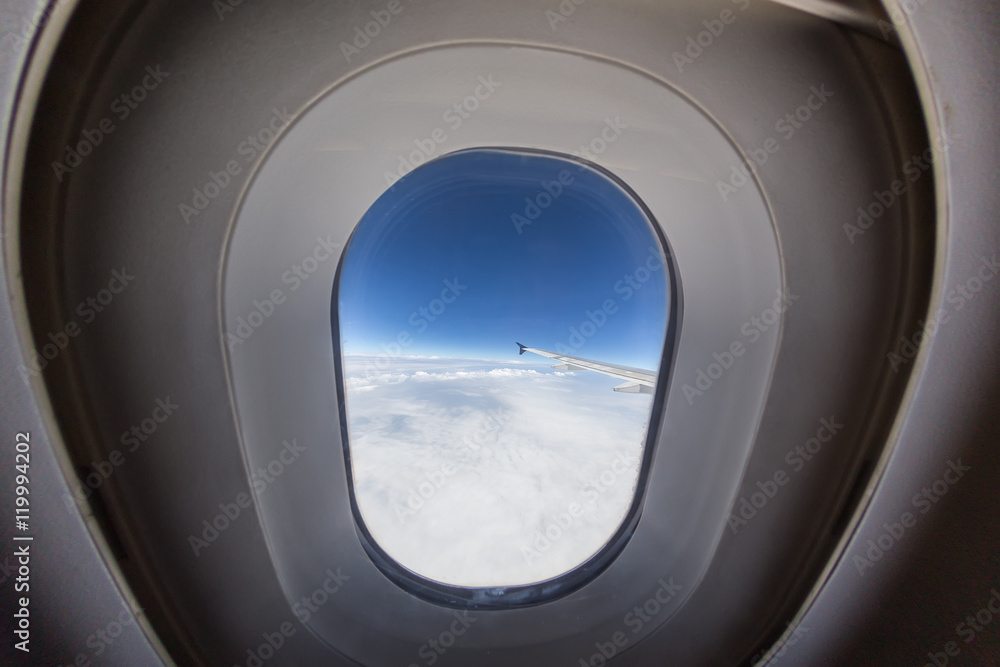 airplane window with wing and cloudy sky behind. airplane window with wing and cloudy sky behind.