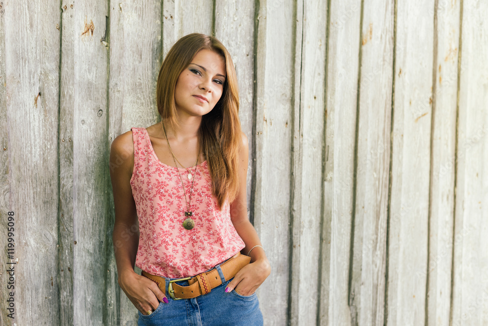 Fototapeta premium Fashion young blond woman in pink Tshirt over pale wooden background