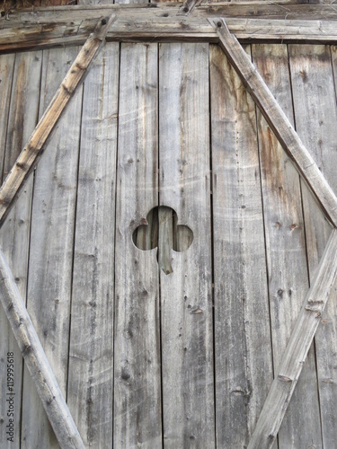 Old wooden door with clover opening