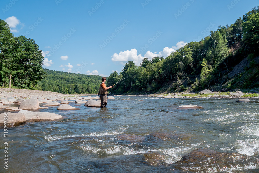 man in a river fishing