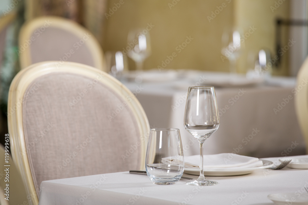 Empty glasses and plates installed in the restaurant, the restaurant served table, white tablecloth and wine Empty glasses and plates installed in the restaurant, the restaurant served table, white tablecloth and wine
