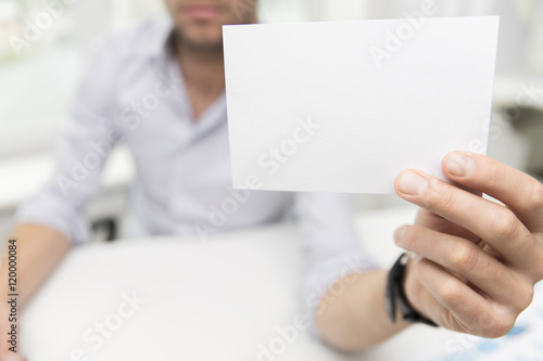 close up of businessman with blank paper at office