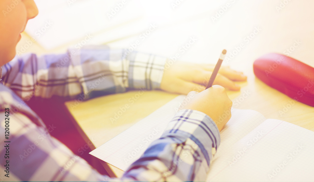close up of schoolboy writing test at school close up of schoolboy writing test at school