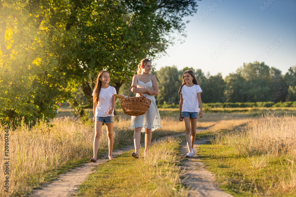 Beautiful mother walking to picnic with her two daughter Beautiful mother walking to picnic with her two daughter