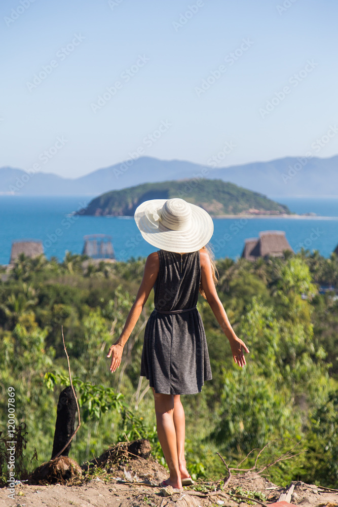 woman in a dress is traveling on the precipice of the mountain in a white hat Vietnam