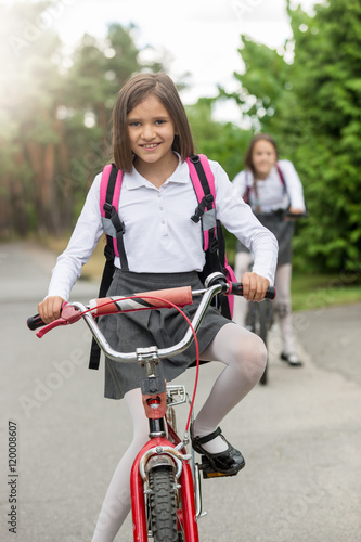 Portrait of smiling girl in school uniform riding bicycle