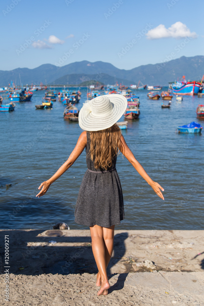 Woman near the water in the harbor boat tour Vietnam in white hat