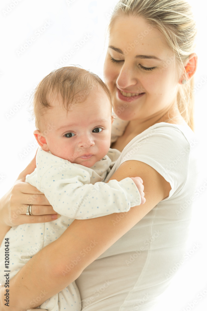 Toned portrait of smiling caring mother cuddling her 3 months ol Toned portrait of smiling caring mother cuddling her 3 months ol