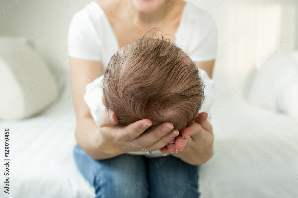 Closeup of mother's hands holding head of sleeping 3 months old Closeup of mother's hands holding head of sleeping 3 months old