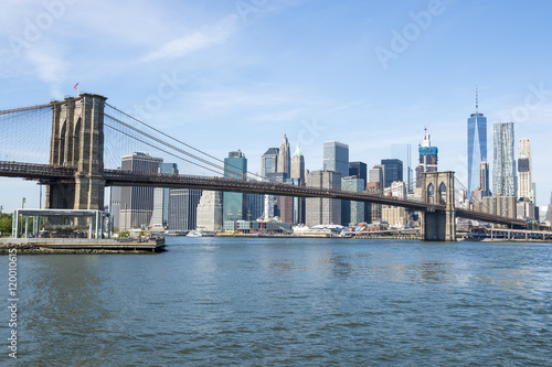 New York City skyline view of Brooklyn Bridge and Downtown Manhattan on bright summer afternoon © lazyllama