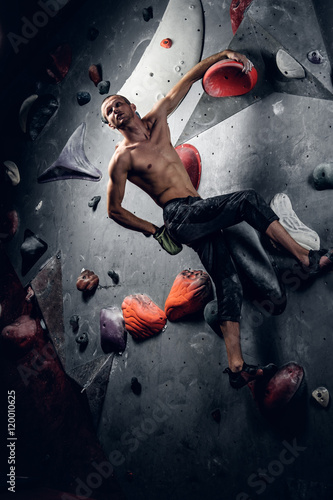 Man climbing on an indoor climbing wall.