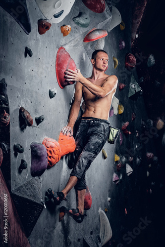 Man climbing on an indoor climbing wall.