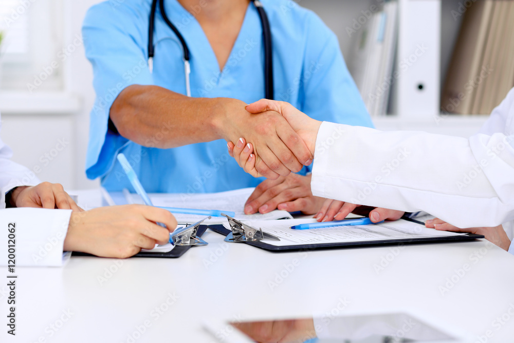 Doctors shaking hands to each other finishing up medical meeting Doctors shaking hands to each other finishing up medical meeting