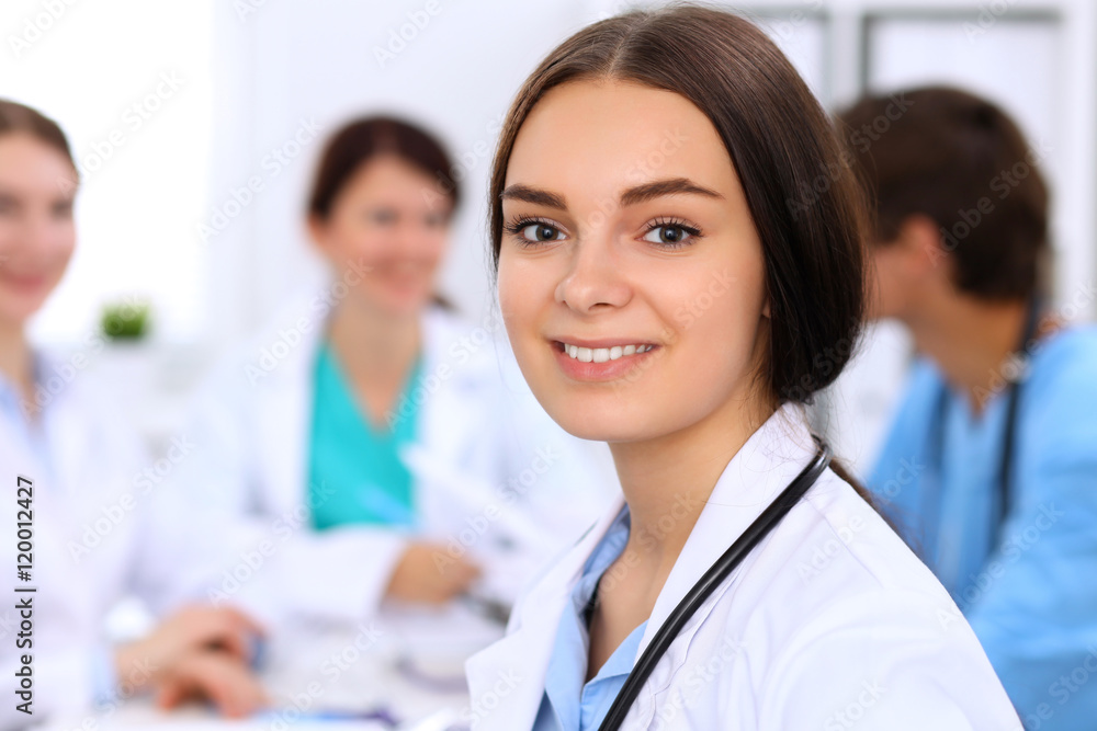 Happy doctor woman with medical staff at the hospital sitting at the table and discussing medical history Happy doctor woman with medical staff at the hospital sitting at the table and discussing medical history