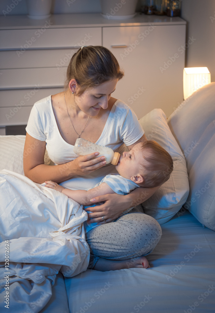 Φωτογραφία Portrait of young mother giving bottle with milk to her baby in