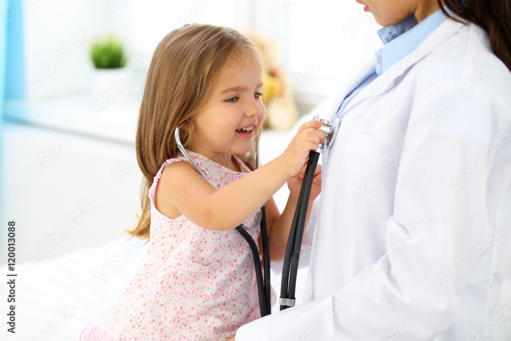 Φωτογραφία Happy little girl at  health exam at doctor's office
