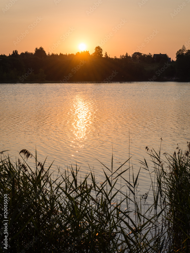 Beautiful summer sunset at the lake with blue sky, red and orang Beautiful summer sunset at the lake with blue sky, red and orang