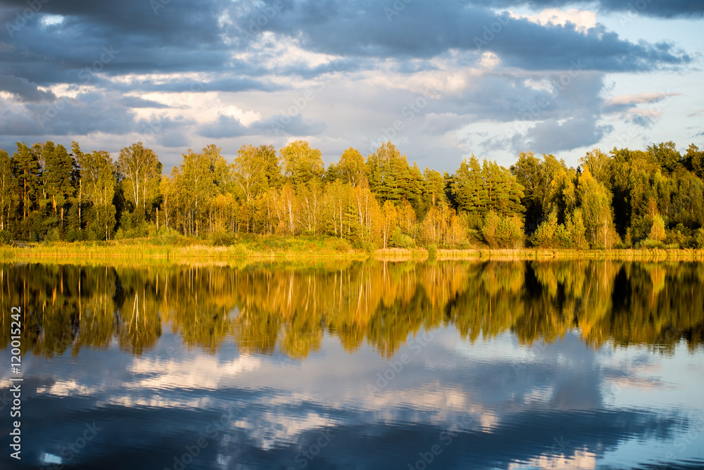 Fototapeta premium Beautiful autumn sunset at the lake with blue sky, red and orang