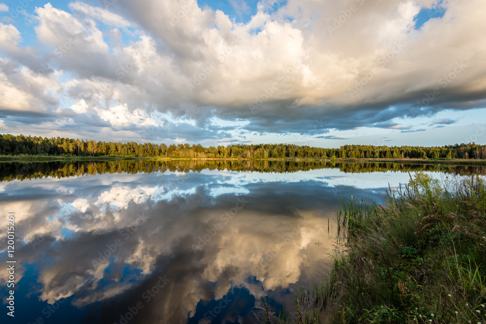 Beautiful summer sunset at the lake with blue sky, red and orang