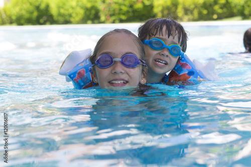 Happy Girl and Boy Enjoying in Swimming Pool