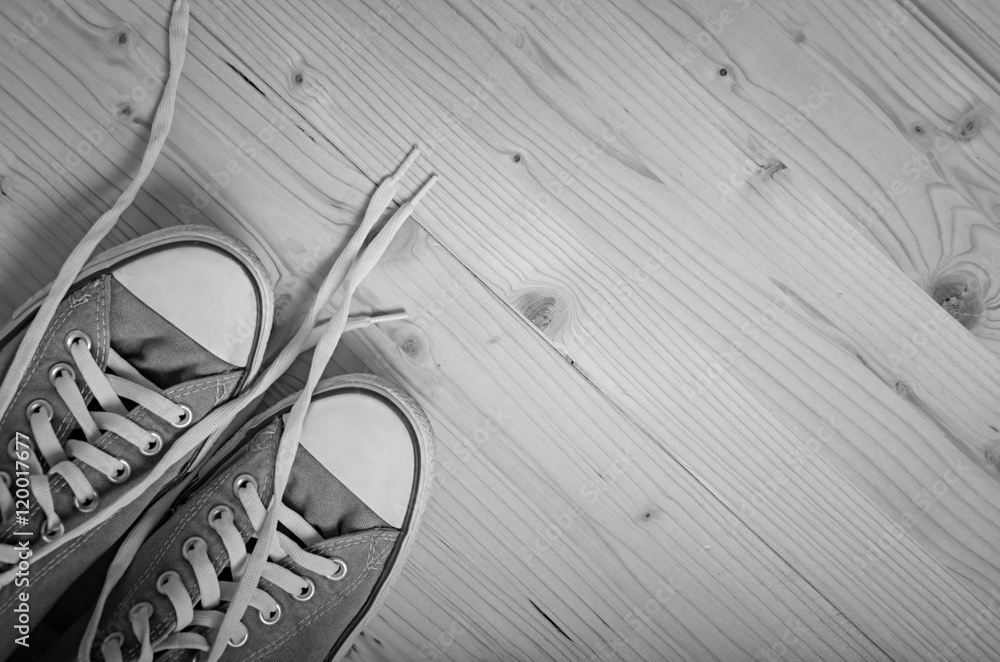 Sneakers on wooden background. Black and white image. Sneakers on wooden background. Black and white image.