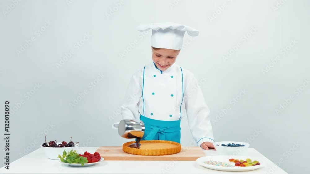 Girl pouring chocolate on cake. Young chef cook preparing a cake Girl pouring chocolate on cake. Young chef cook preparing a cake