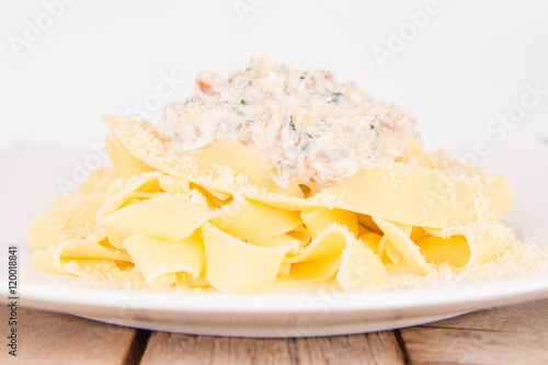 Pappardelle with chanterelle and cream on a wooden background