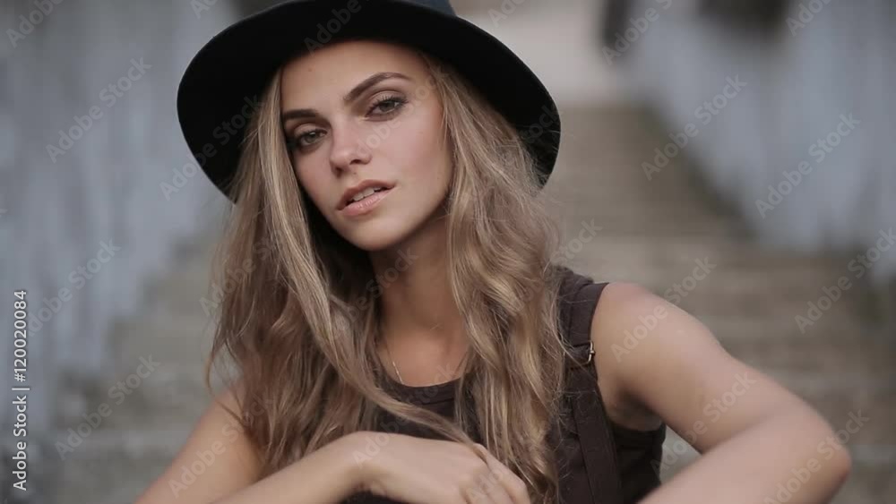 pretty young girl in a black hat looking up on a gray background pretty young girl in a black hat looking up on a gray background
